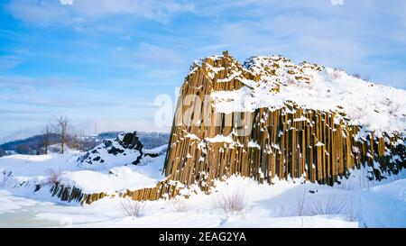 Panska skala - Gesteinsbildung von fünfeckigen und sechseckigen Basaltsäulen. Sieht aus wie riesige Orgelpfeifen. Im Winter von Schnee und Eis bedeckt. Kamenicky Senov, Tschechische Republik. Stockfoto