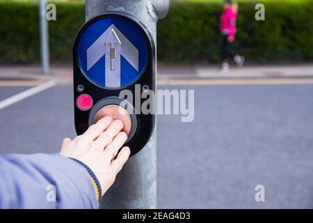 Drucktaste mit Außenhand für Ampel. Fahren Sie an der Kreuzung mit der Ampel. Taste des Mechanismus leuchtet Ampeln auf der Straße. System Stockfoto