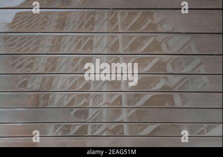 Terrassendielen nach Regen und ihre Reflexionen können im Wasser gesehen werden. Kopierbereich, selektiver Fokus. Stockfoto