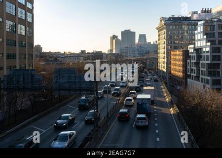 Highway von oben mit vorbeifahrenden Autos und Gebäuden in der Ferne. Autofahren auf dem Brooklyn Expressway Stockfoto