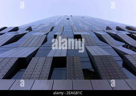 Blick auf ein hohes Hochhaus aus Glas und Stahl. Fenster des Hightech-Gebäudes. Abstrakte moderne Architektur. Geometrischer Hintergrund der Rahmen. Stockfoto