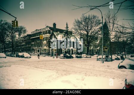 Winterszene mit schneebedeckten Autos, die entlang der Straßen in Brooklyn, NY, geparkt sind Stockfoto