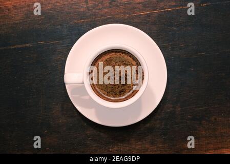 Tasse Kaffee auf braunem Holztisch. Draufsicht Stockfoto