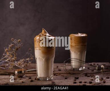 Dalgona Kaffee. Schlagsahngetränk mit Instant-Kaffee beliebt in Korea cremigen Cocktail in hohen Gläsern. Dunkle launische Food-Fotografie Stockfoto