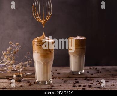 Dalgona Kaffee. Schlagsahngetränk mit Instant-Kaffee beliebt in Korea cremigen Cocktail in hohen Gläsern. Dunkle launische Food-Fotografie Stockfoto