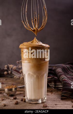 Dalgona Kaffee. Schlagsahngetränk mit Instant-Kaffee beliebt in Korea cremigen Cocktail in hohen Gläsern. Dunkle launische Food-Fotografie Stockfoto