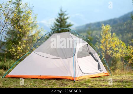 Leeres Campingzelt auf dem Campingplatz mit Blick auf majestätische hohe Berggipfel in der Ferne. Wandern in der wilden Natur und aktiv Trail Reisen conce Stockfoto