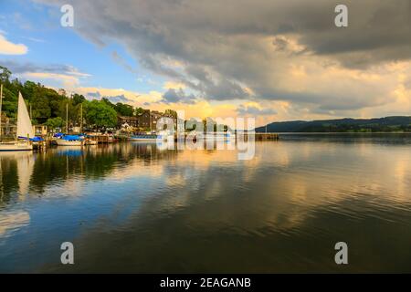 Blick über den Lake Windermere im englischen Lake District, Waterhead in Ambleside, Cumbria, Nordwestengland in der Abenddämmerung mit Booten, die an der Küste festgemacht sind Stockfoto