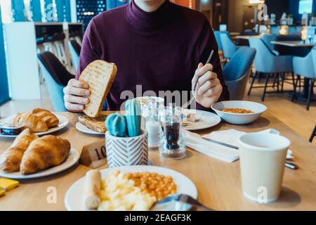 Mann, der vegetarisches englisches Frühstück im Hotelrestaurant isst. Kontinentales Frühstückskonzept. Selektiver Fokus, Kopierbereich Stockfoto