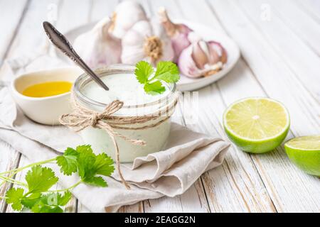 Koriander Knoblauchsauce mit Limettensaft und Olivenöl in Ein Glas Stockfoto