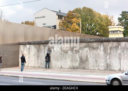 Berlin Deutschland Besucher spielen um einen erhaltenen Teil der Mauer im Dokumentationszentrum der Gedenkstätte C der Berliner Mauer in der Bernauer Straße. Stockfoto