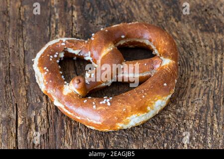 bayerische Butterbrezel auf dunklem Holz Stockfoto