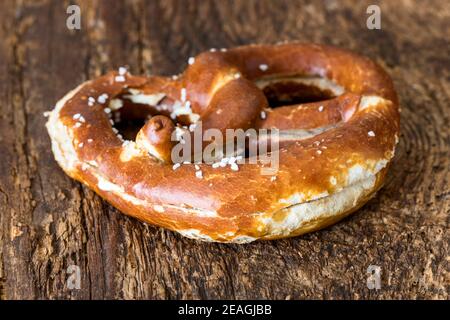 bayerische Butterbrezel auf dunklem Holz Stockfoto