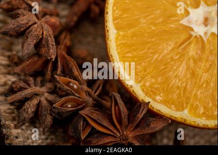 Eine halbe Orange und ein Sternanis auf einem Holztisch. Nahaufnahme, selektiver Fokus. Stockfoto