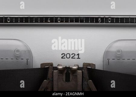 Eingabe von Text oder Ziffer 2021 auf vintage manuelle Schreibmaschine. Nahaufnahme der Jahreszahl der Schreibvorgänge auf dem White Paper. Aufgenommen im Makro. Konzept des neuen Jahres. Stockfoto