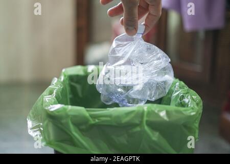 Man Hand Ansicht während Trashing gebrauchte Plastikflasche auf separaten Mülltonne, Recycling Stockfoto