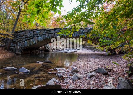 Herbstlaub umrahmt die Boulder Bridge im Rock Creek Park, Washington, DC im Herbst. Stockfoto