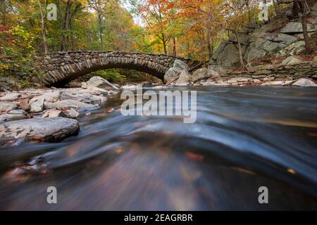 Herbstlaub umrahmt die Boulder Bridge im Rock Creek Park, Washington, DC im Herbst. Stockfoto