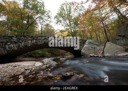 Herbstlaub umrahmt die Boulder Bridge im Rock Creek Park, Washington, DC im Herbst. Stockfoto