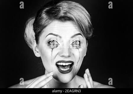 Frauen Drama und Schock Konzept. Mädchen weinen mit Mascara Ströme auf Gesicht. Frau mit schockierten Gesicht mit Make-up auf grauem Hintergrund, kopieren Raum. Stockfoto