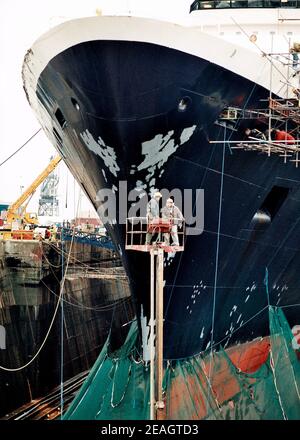 AJAXNETPHOTO. DEZEMBER 1996. SOUTHAMPTON, ENGLAND. - BOGENANSICHT DES CUNARD PASSAGIERSCHIFFES QUEEN ELIZABETH 2 - QE2 - IM KGV TROCKENDOCK, IHR RUMPF IN NETZ GEHÜLLT, DURCHLÄUFT REFIT. FOTO: JONATHAN EASTLAND/AJAX. REF:TC6044 33 13 Stockfoto