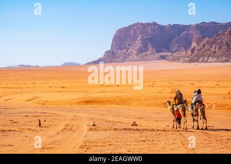 Touristen auf Kamelen durch die wadi Rum Wüste in Jordanien Stockfoto