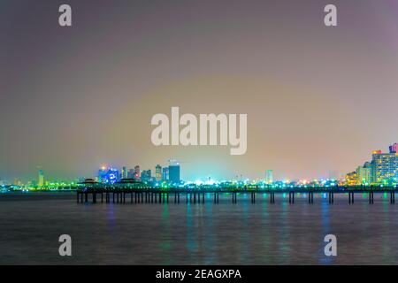 Blick auf einen Pier, der in das Meer in Kuwait während der Nacht eindringt. Stockfoto