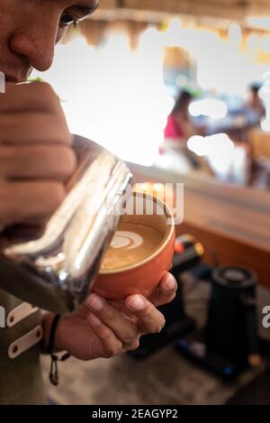 Barista Asian Smiling On Duty Serviert Kaffee Cappuccino Mit Ein Smile Bright Morning Light Professional Stockfoto