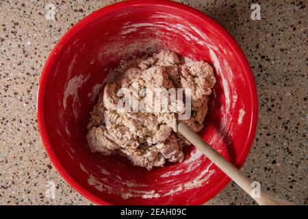 Mischen einer Schüssel mit Zutaten für die Herstellung von Brot. Serie Schritt-für-Schritt Herstellung hausgemachtes Brot. Bild 3 von 13 Stockfoto
