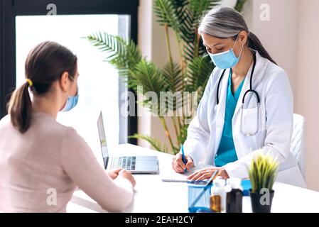 Konsultation eines Arztes der Allgemeinmedizin. Ein Mädchen beim Arzttermin in der Klinik, der Arzt verschreibt Behandlung. Medizinische Versorgung, Gesundheitskonzept Stockfoto