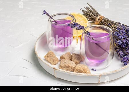 Limonade mit Zitronen und Lavendel. Ein erfrischendes alkoholfreies Getränk mit frischem Obst und einem trockenen Bouquet. Weißer Kitt Hintergrund Stockfoto