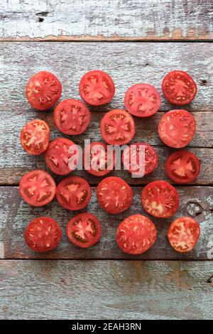 Gesunde Bio-Lebensmittel. Homegrown Erbstück Tomaten in Hälften auf alten schäbigen blauen Brettern copyspace geschnitten Stockfoto