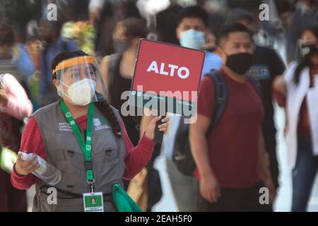 Mexiko-Stadt, Mexiko-Stadt, Mexiko. Februar 2021, 9th. Ein Offizier hält ein Schild an die Menschen folgen den Regeln, um Agglomerationen zu verhindern. Die mexikanische Regierung erlaubte die Wiedereröffnung von Geschäften, einige Geschäfte machen außerhalb verkaufen, um Menschenmassen zu verhindern, als ein Versuch, die Ausbreitung des Virus zu verhindern 9. Februar 2021 in Mexiko-Stadt, Mexiko Credit: Angel Morales Rizo/eyepix/ZUMA Wire/Alamy Live News Stockfoto