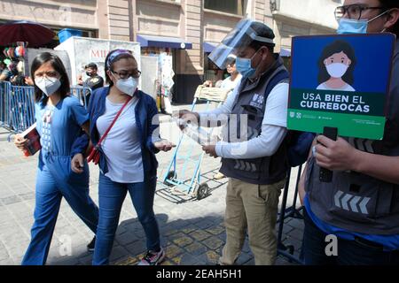 Mexiko-Stadt, Mexiko-Stadt, Mexiko. Februar 2021, 9th. Ein Offizier hält ein Schild an die Menschen folgen den Regeln, um Agglomerationen zu verhindern. Die mexikanische Regierung erlaubte die Wiedereröffnung von Geschäften, einige Geschäfte machen außerhalb verkaufen, um Menschenmassen zu verhindern, als ein Versuch, die Ausbreitung des Virus zu verhindern 9. Februar 2021 in Mexiko-Stadt, Mexiko Credit: Angel Morales Rizo/eyepix/ZUMA Wire/Alamy Live News Stockfoto