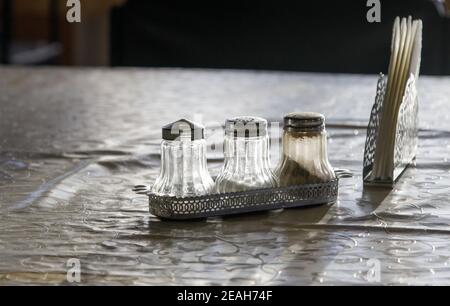 Altmodische Glas Pfeffer und Salz Shaker auf einem alten Tisch in einem öffentlichen Café Stockfoto