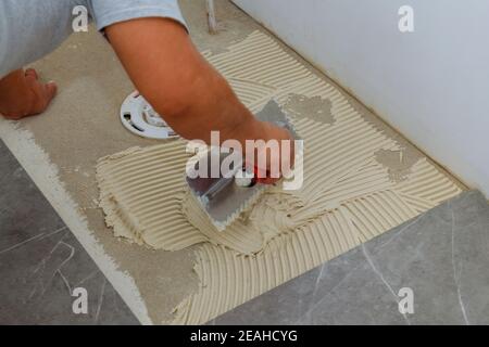 Vorbereitung vor dem Gießen von Beton in Kelle Klebstoff auf den Boden einen ausstreuen nassen Mörtel Stockfoto