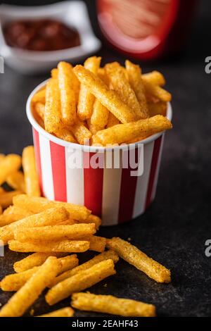 Pommes frites. Gesalzener Snack. Kartoffelchips in Papierbecher. Stockfoto