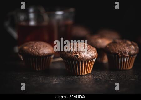 Schokoladen-Muffins. Süße dunkle Cupcakes auf schwarzem Tisch. Stockfoto