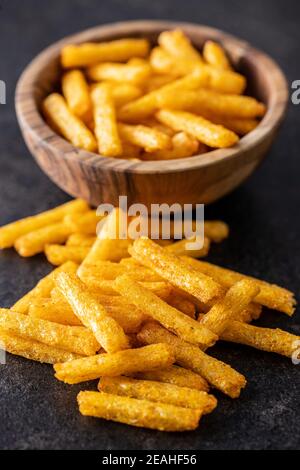 Pommes frites. Gesalzener Snack. Kartoffelchips auf schwarzem Tisch. Stockfoto