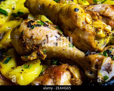 Bratkartoffeln mit Hühnerschenkel gewürzt mit Kräutern. Bratkartoffeln. Hühnerfleisch. Kartoffelbraten mit Geflügel. Vogelpfote. Speisekarte. Wohnküche. Coo Stockfoto