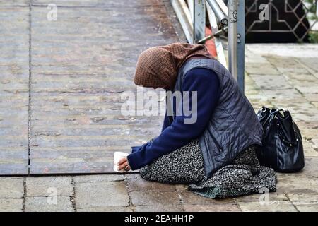 Bettler Zigeuner Frau betteln um Geld Passanten kniend auf die Masse Stockfoto