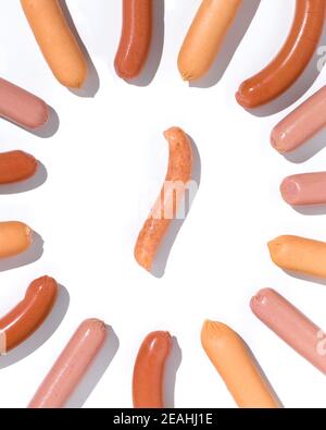 Hausgemachte Wurst umgeben von verschiedenen Würstchen auf dem weißen Hintergrund Stockfoto