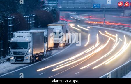 Lehrte, Deutschland. Februar 2021, 10th. LKW-Fahrer haben auf der harten Schulter der Autobahn A2 geparkt, um die Nacht zu verbringen (Long Shutter Speed Shot). Aufgrund überfüllter oder unpassierbarer Parkplätze parken Lastwagen kilometerweit direkt auf der harten Schulter der A2. Kredit: Julian Stratenschulte/dpa/Alamy Live Nachrichten Stockfoto