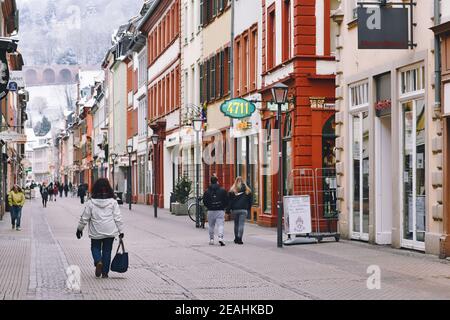 Heidelberg, Deutschland - Februar 2020: Historische Innenstadt am kalten Wintertag mit wenigen Leuten, die durch die Einkaufsstraße mit geschlossenen Geschäften schlendern Stockfoto