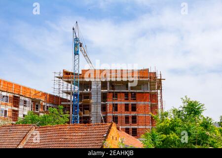 Gerüst- und Kran sind gegen unvollendete Bauwerk, Gebäude im Bau. Stockfoto