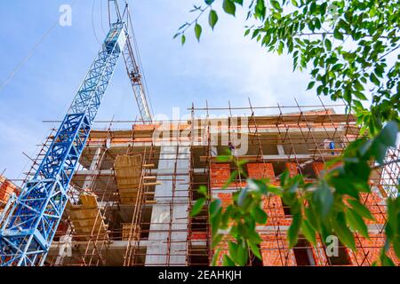 Gerüst- und Kran sind gegen unvollendete Bauwerk, Gebäude im Bau. Stockfoto