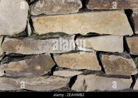 Eine Wand aus grauen Steinen in verschiedenen Größen, die Textur von Mauerwerk Stockfoto