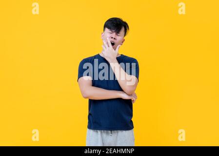 Müde schläfrig asiatischen Mann gähnend mit Hand bedeckt Mund leiden Von Schlaflosigkeit Stockfoto