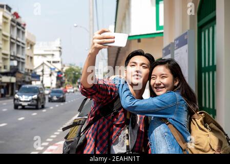 Junges asiatisches Touristenmädchen, das selfie während der Sommerferien in Bangkok, Thailand, mit Freund nimmt Stockfoto