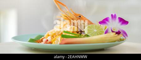 Köstliche asiatische Lebensmittel, heiße frische Garnelen Pad Thai Nudelgericht auf Küchentisch Banner Hintergrund Stockfoto